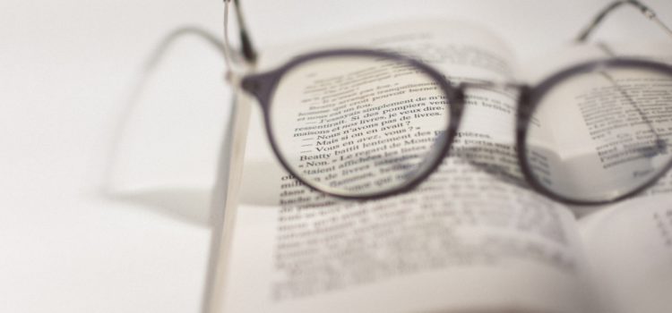 black framed eyeglasses on white book page